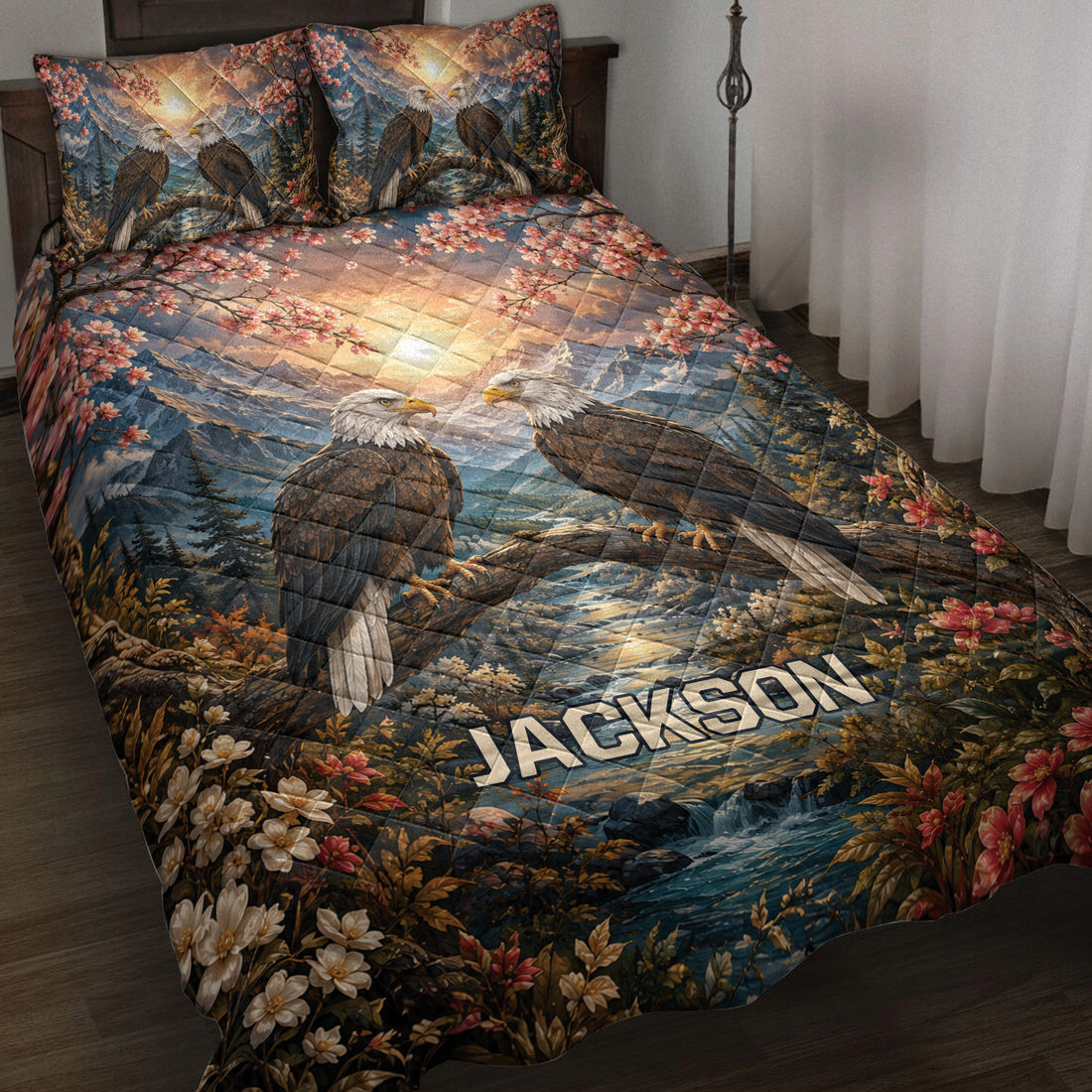 Eagle quilt blanket displayed on a bed with mountain scenery, flowering branches, forest, and river artwork