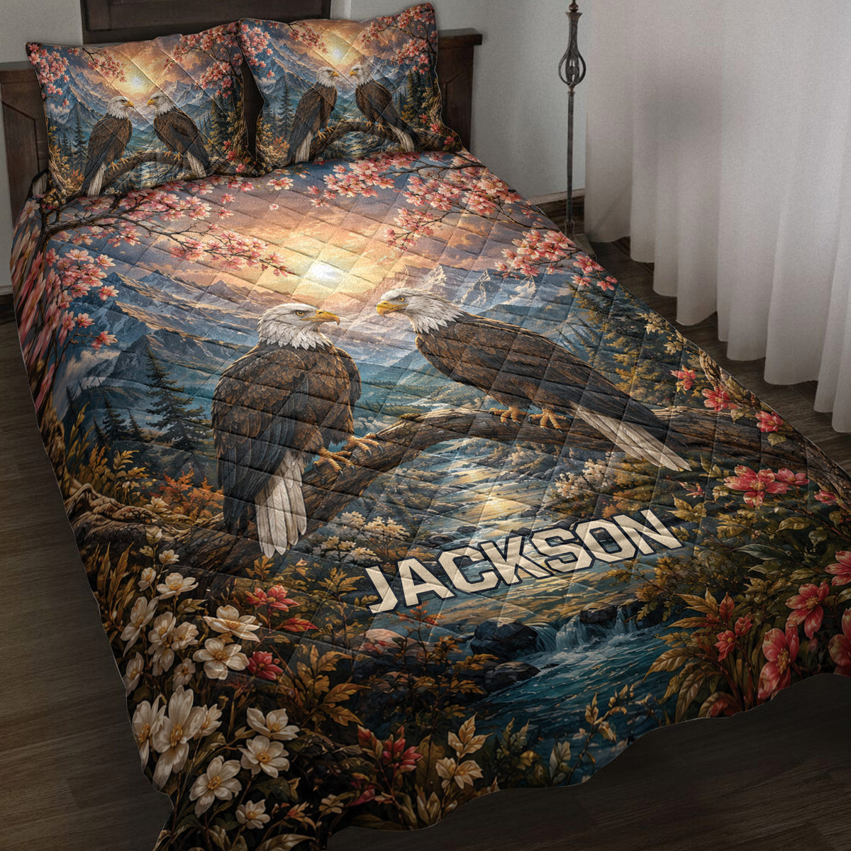 Eagle quilt blanket displayed on a bed with mountain scenery, flowering branches, forest, and river artwork