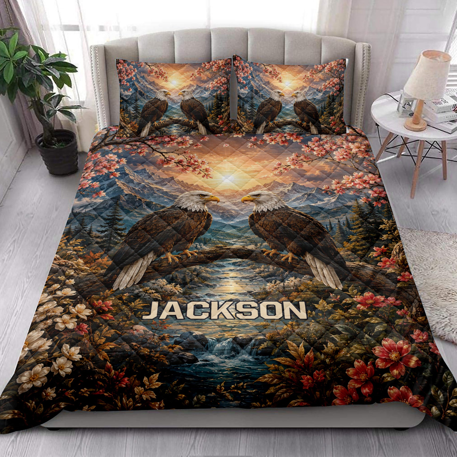 Eagle quilt blanket styled in a bright bedroom with mountain scenery, blossoms, and river artwork