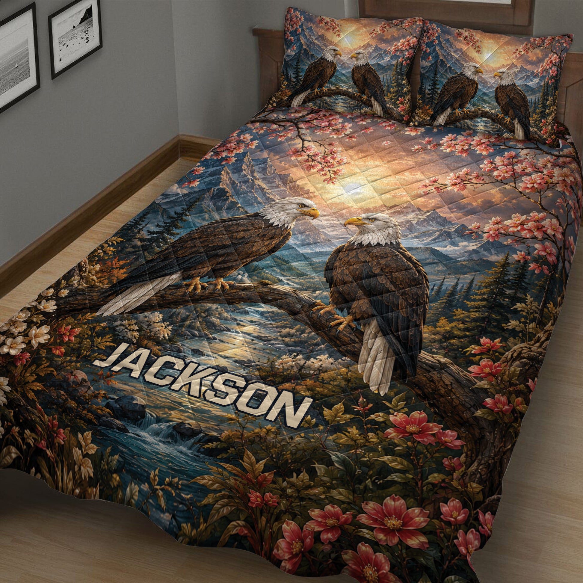 Close view of an eagle quilt blanket featuring paired eagles, mountain scenery, blossoms, and a flowing river