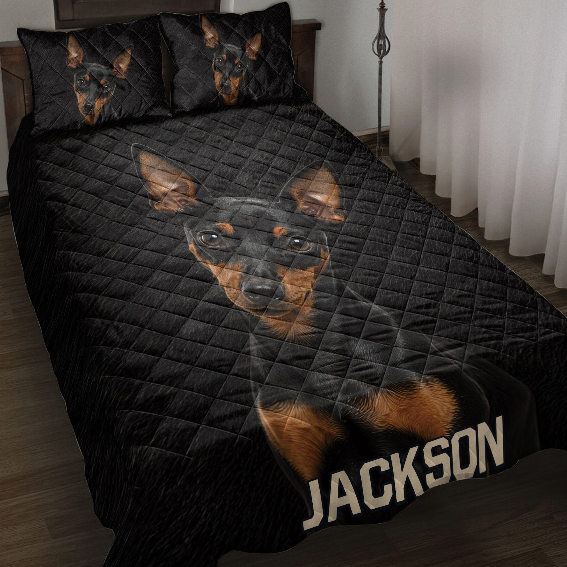 Black quilt blanket featuring multiple black-and-tan Miniature Pinscher portraits in a bedroom setting
