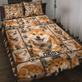 Shiba Inu quilt blanket spread across a bed with plaid accents, paw prints, and repeated dog portraits