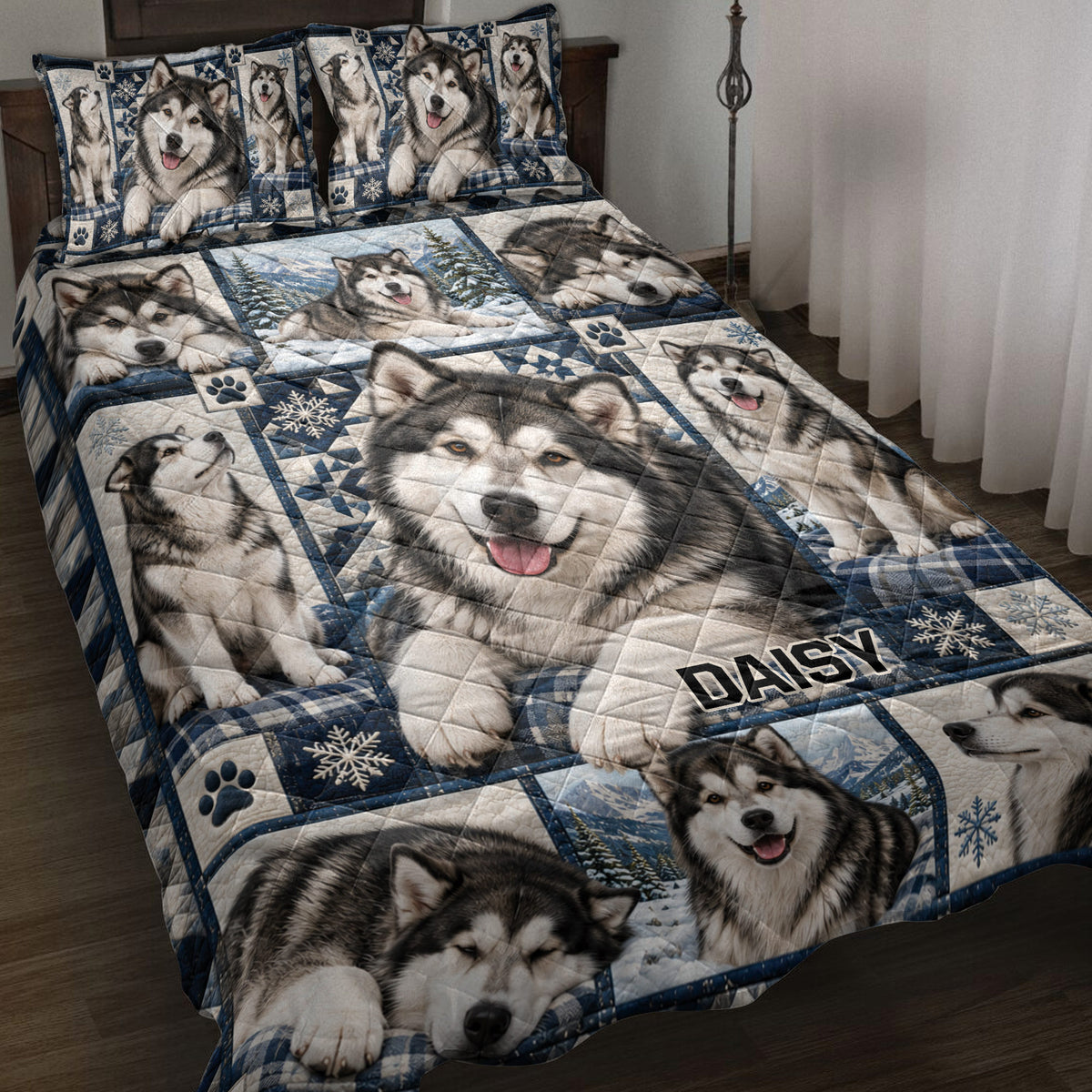 Alaskan Malamute quilt blanket displayed on a bed with snowy mountain scenes, paw prints, and blue plaid accents