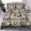 Ragdoll cat quilt blanket styled on a bed in a bright bedroom with floral blue accents