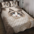 Ragdoll cat quilt blanket displayed on a bed with blue-eyed cat artwork and neutral diamond quilting