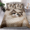 Ragdoll cat quilt blanket styled in a bright bedroom with a large blue-eyed cat portrait