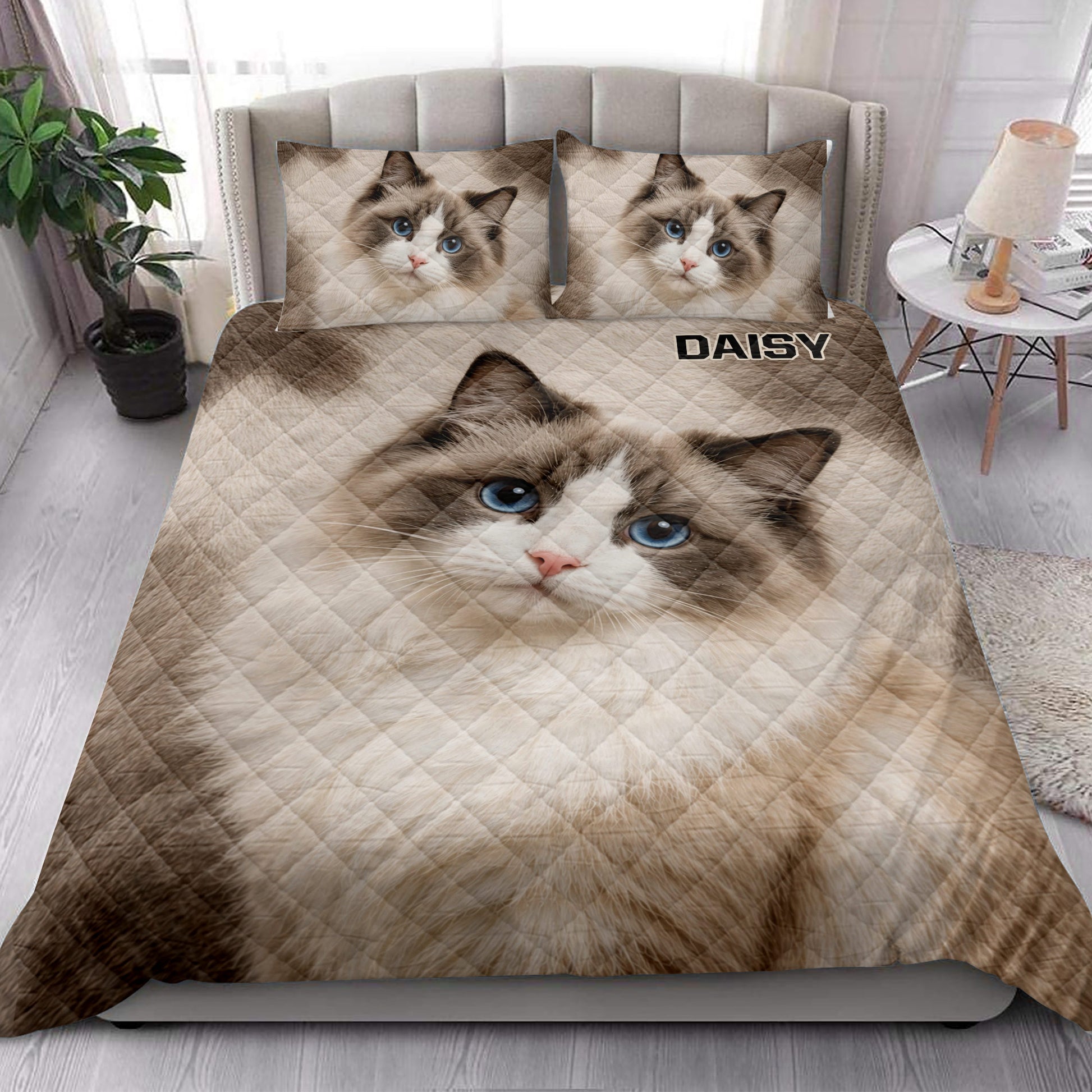 Ragdoll cat quilt blanket styled in a bright bedroom with a large blue-eyed cat portrait
