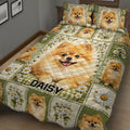Close bedroom view of a Pomeranian quilt blanket featuring daisy panels and playful dog portraits