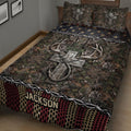 Close angled view of hunting quilt bedding with large antlers, camouflage foliage, and rustic decorative borders