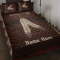 American Native feather quilt blanket styled on a bedroom bed with earthy brown geometric artwork