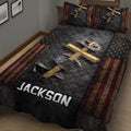 Faith-inspired cross quilt blanket displayed on a bedroom bed with distressed patriotic artwork