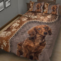 Close view of dachshund quilt blanket featuring a large dog portrait, paw prints, and illustrated sleeping dogs