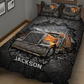 Close-up of a trucker quilt blanket featuring a large orange semi-truck against a rugged black background