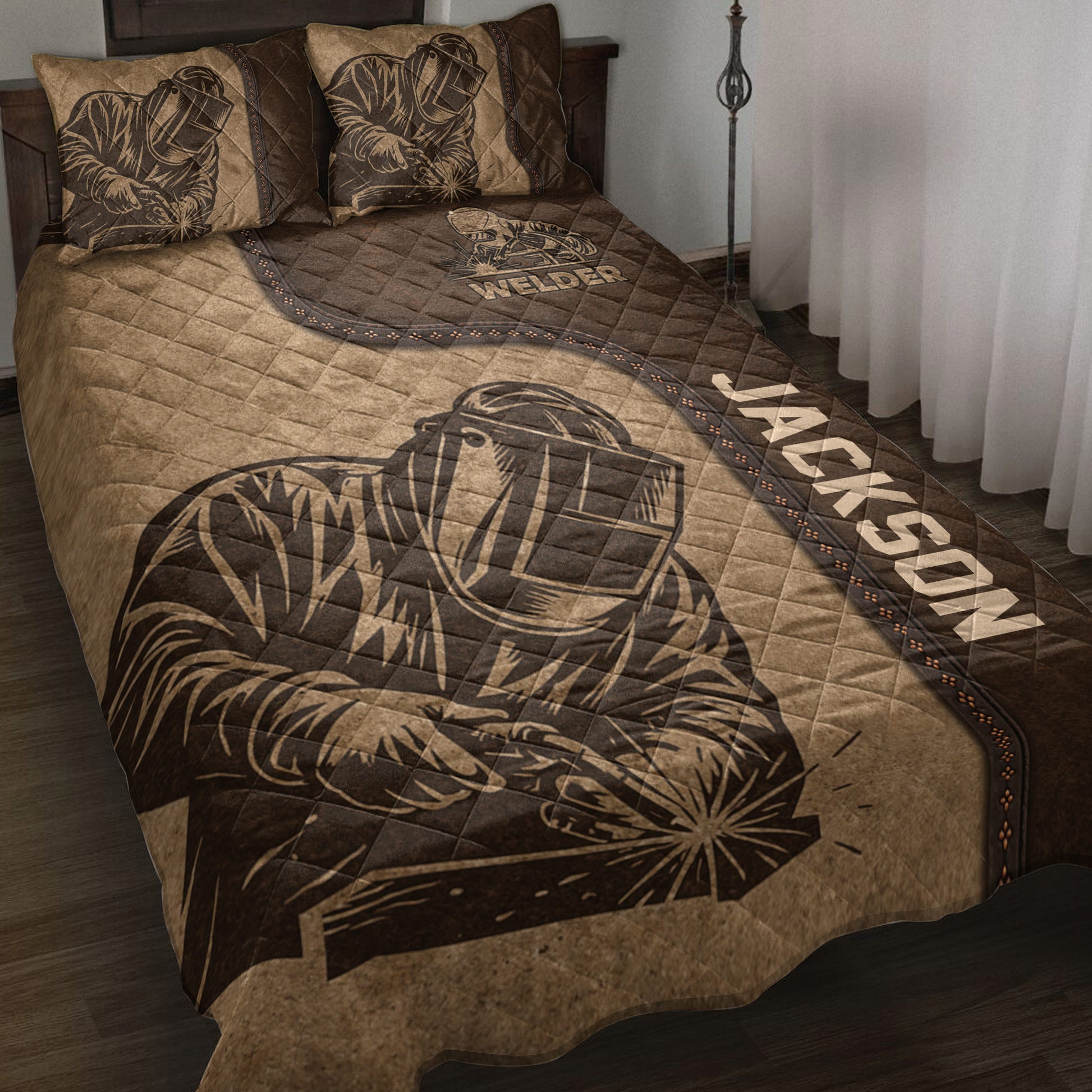 Brown welder quilt blanket displayed on a bed with protective helmet artwork and industrial welding details
