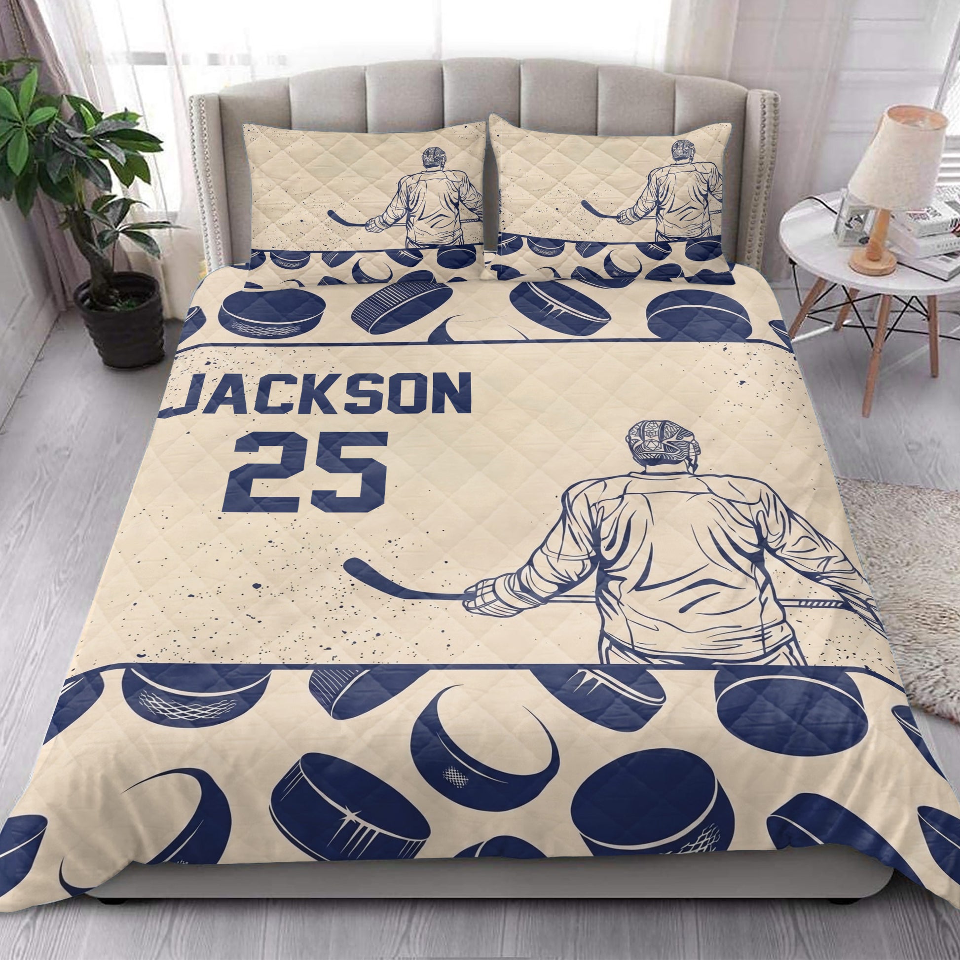 Hockey quilt blanket styled in a bright bedroom with navy player and puck artwork