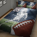 Close view of football quilt blanket with player artwork, stadium lighting, field graphics, and large football detail
