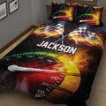 Close-up racing quilt blanket with checkered flags, flames, speedometer graphics, and black background