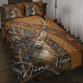 Hunting quilt blanket displayed on a bed with realistic deer, antlers, woodland camouflage, and rustic brown artwork