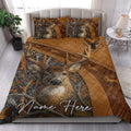 Hunting quilt blanket styled in a bedroom with a large deer portrait, antlers, and rustic woodland artwork