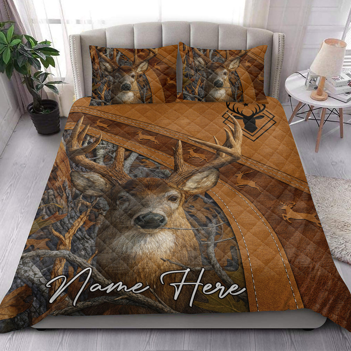 Hunting quilt blanket styled in a bedroom with a large deer portrait, antlers, and rustic woodland artwork