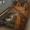 Rustic hunting quilt bedding displayed on a bed with deer portraits, antlers, and brown woodland camouflage
