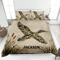 Duck hunting quilt blanket displayed on a bed with flying camouflage ducks and marsh cattails
