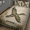 Duck hunting quilt displayed on a wooden bed with flying ducks and cattail marsh artwork