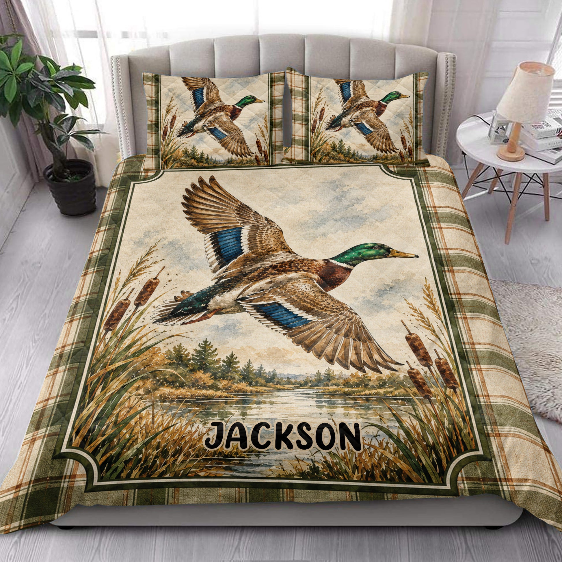 Duck hunting quilt blanket styled in a bright bedroom with flying mallard artwork and plaid edging