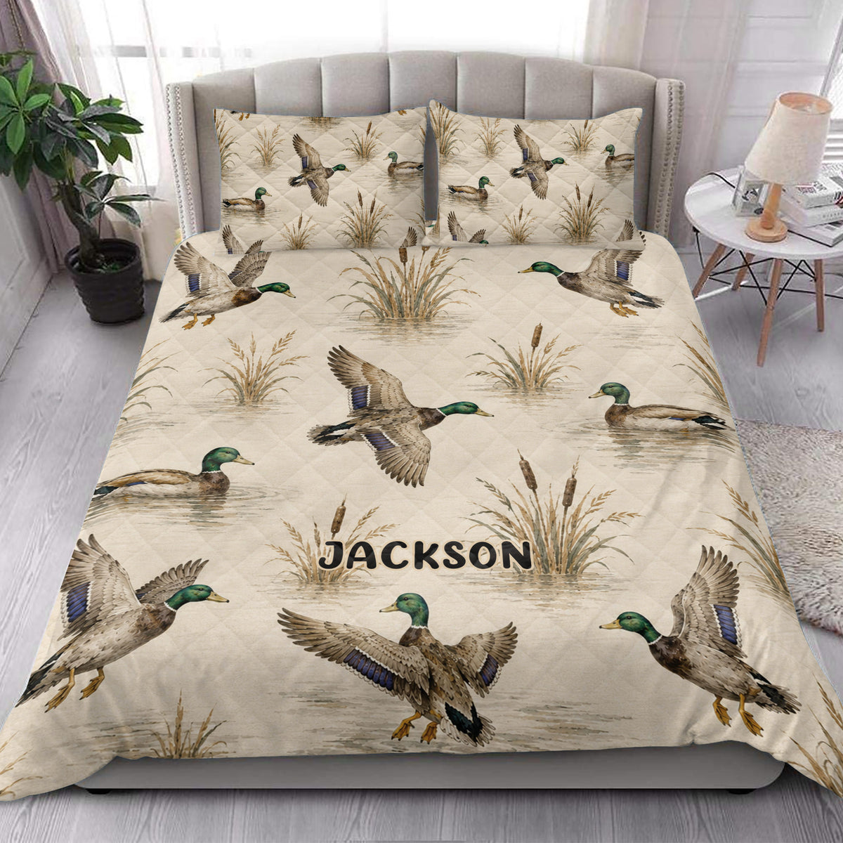 Duck hunting quilt blanket styled in a bright bedroom with mallards, cattails, and wetland artwork