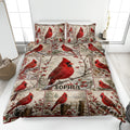 Cardinal quilt blanket displayed on a bed with red birds, winter branches, berries, and a custom central panel