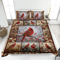 Cardinal quilt blanket displayed on a bed with red birds, winter branches, berries, and coordinating pillows