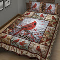 Close bedroom view of a cardinal quilt blanket featuring red birds on snowy branches and berry accents
