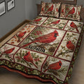 Close bedroom view of a cardinal quilt blanket featuring red birds, autumn leaves, blossoms, and pinecones