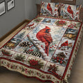 Winter cardinal quilt bedding displayed on a bed with red birds, pine branches, berries, and holiday decor