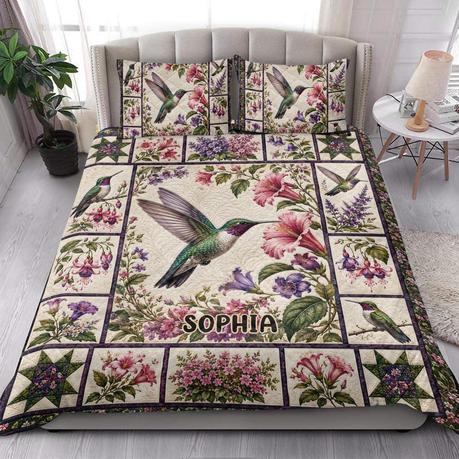 Hummingbird floral quilt blanket styled on a bed in a bright botanical bedroom setting