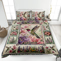 Hummingbird quilt blanket spread across a bed with colorful flowers and matching bird-themed pillows