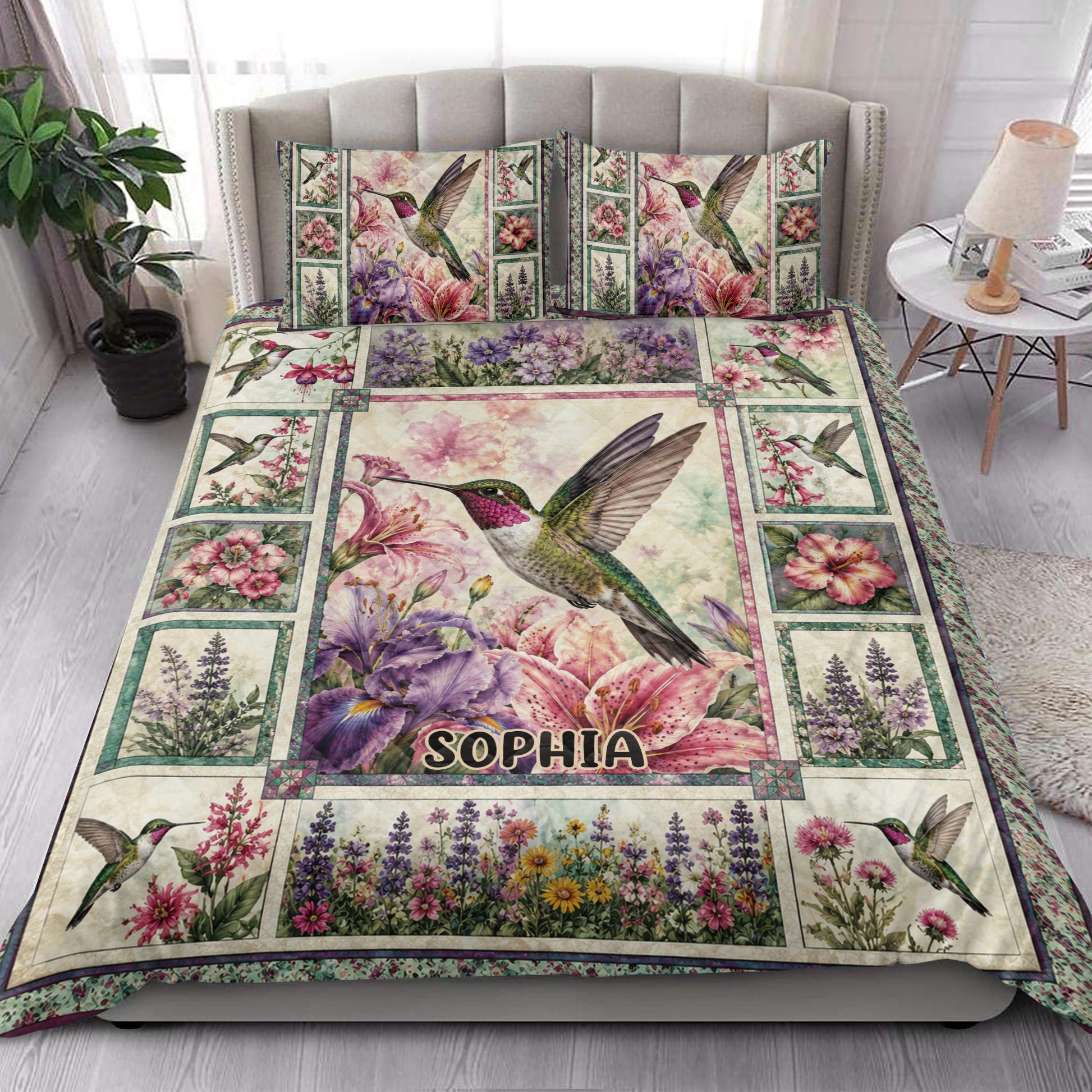 Hummingbird quilt blanket styled on a bright bedroom bed with floral panels and bird artwork