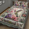 Close bedroom view of a hummingbird quilt blanket with colorful flowers and detailed botanical panels