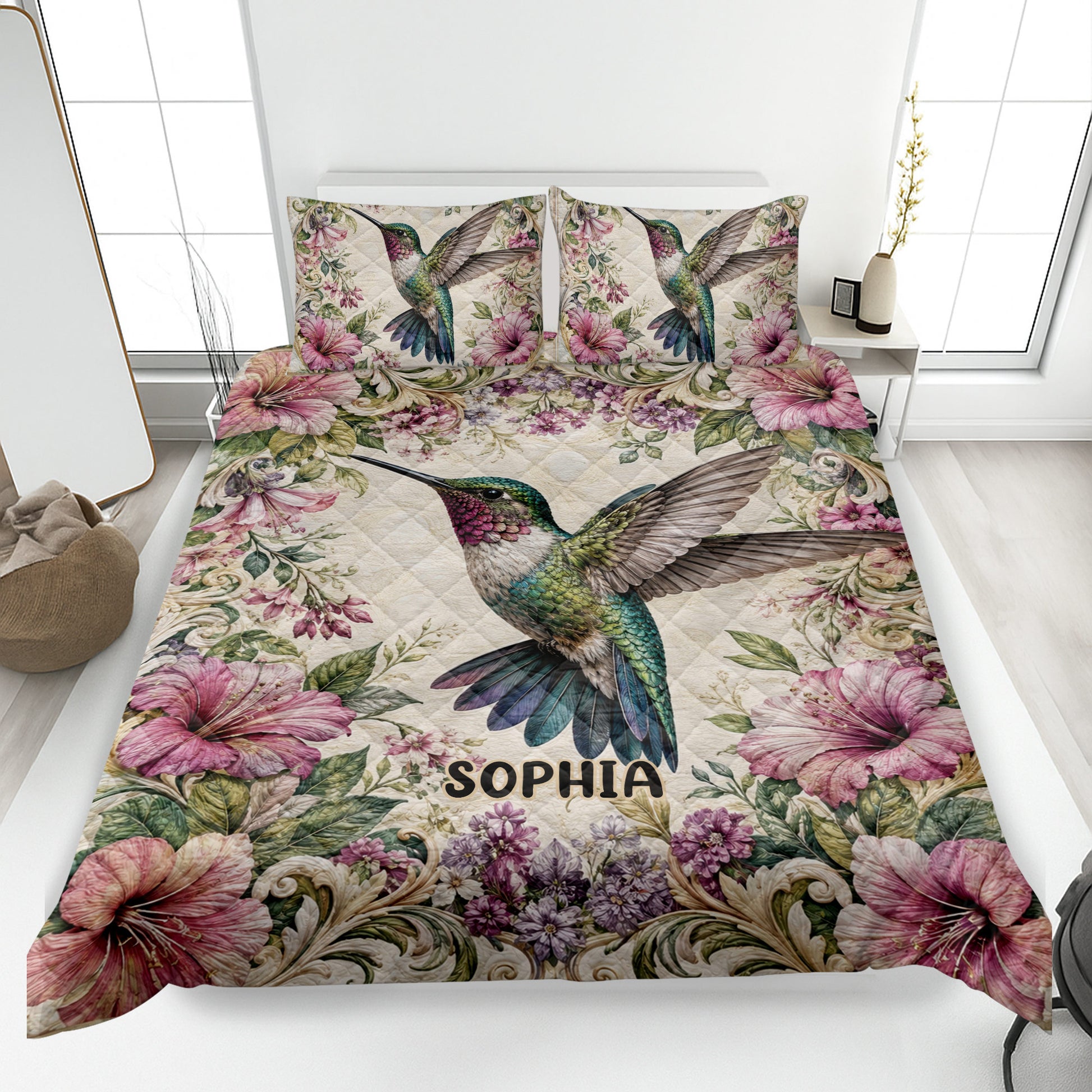 Hummingbird quilt blanket displayed on a bed with colorful flowers and detailed bird artwork