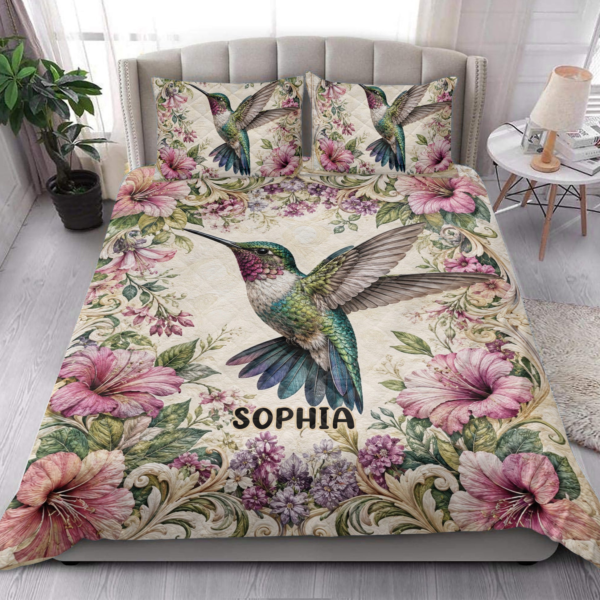 Hummingbird floral quilt blanket styled on a bright bedroom bed with matching bird artwork