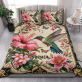 Hummingbird quilt blanket styled in a bright bedroom with tropical flowers and butterfly accents