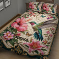Close view of hummingbird quilt bedding with hibiscus flowers, tropical foliage, and ornate borders