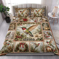 Hummingbird quilt blanket styled on a bedroom bed with poinsettias, ornaments, lanterns, and evergreen branches