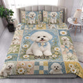 Bichon Frise quilt blanket styled on a bed with matching floral dog artwork and blue, cream, and gold tones
