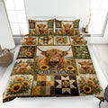 Highland cow quilt blanket displayed on a bed with sunflower panels and rustic patchwork artwork