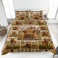 Highland cow quilt blanket spread across a bed with farmhouse scenes, sunflowers, daisies, and rustic patchwork