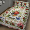 Close bedroom view of a ladybug quilt blanket covered in daisies, peonies, greenery, and garden insects