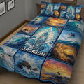 Close view of a surfing quilt blanket featuring surfers, curling waves, sunset colors, and ocean-inspired artwork