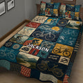 Close bedroom view of bicycle quilt bedding with cycling artwork, mountain scenery, gears, helmets, and bicycles