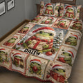 Close bedroom view of a Christmas frog quilt featuring gift-holding frogs, ornaments, and holiday colors